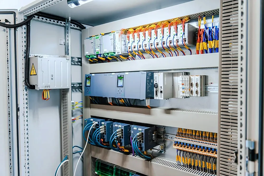 An open industrial control cabinet with modules and wiring